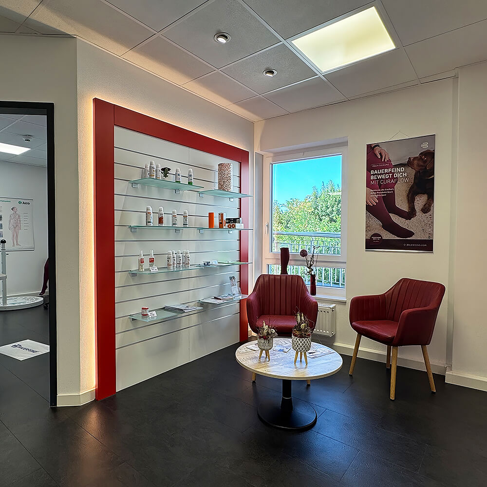 Beratungs- und Wartebereich mit Sitzgruppe, Produktregalen und dekorativem Tisch in einer Orthopädie-Praxis